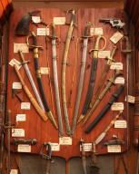 collection d'armes blanches et d'armes à feu : épée (4) ; sabre (8) ; lance (2) ; poignard (4) ; carabine (1) ; fusil (4) ; revolver (1) ; corne à poudre (1)