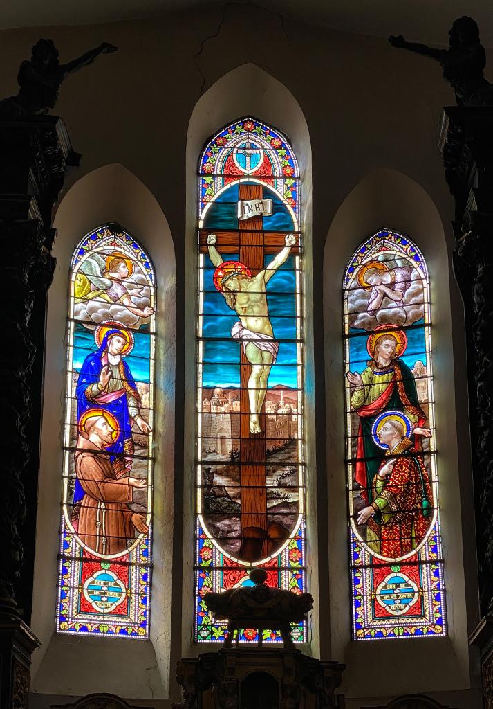 ensemble de trois verrières à personnages : Christ en croix entre saint Jean et Marie en présence de saint Etienne et saint François d'Assise